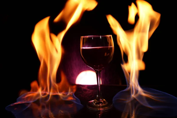Üveg Vörösbor Üvegasztalon Tűzzel Körülötte Fekete Háttér Romantikus Fotó — Stock Fotó