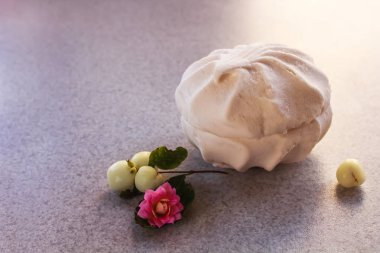 beyaz marshmallow ve yeşil yaprakları ile pembe güzel bir çiçek ile çilek masada yalan. metin için arka plan