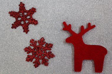 Kırmızı keçeden oyulmuş bir geyik, kendin yap, gümüş arka planda parıldayan iki kırmızı yıldız. İlginç bir 