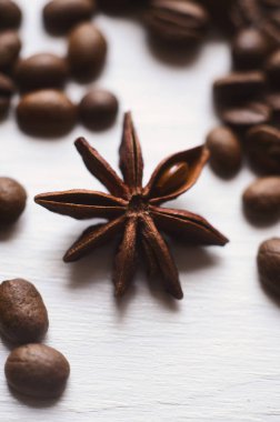 Beyaz arka plan üzerinde yakın çekim yıldız anason ve kahve çekirdekleri