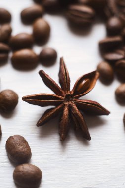 Beyaz arka plan üzerinde yakın çekim yıldız anason ve kahve çekirdekleri