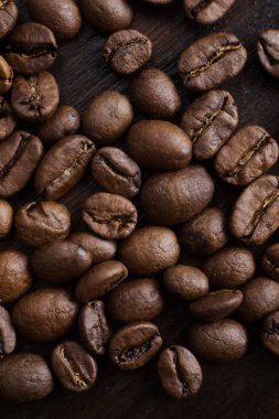 Koyu ahşap arka plan üzerinde yakın çekim kahve çekirdekleri