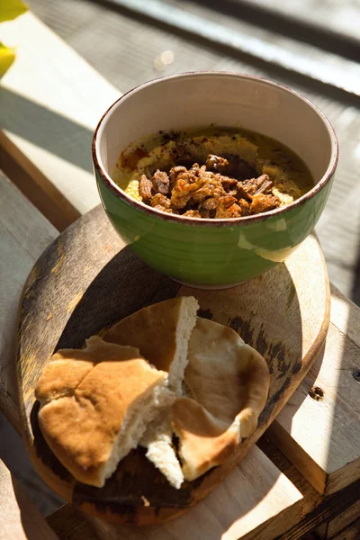 Ahşap arka plan üzerinde bir tabakta haşlanmış sığır eti ile Nohut humus