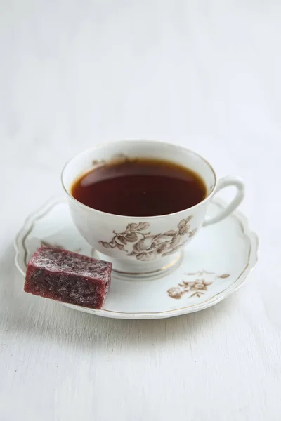 Par de chá de porcelana com chá e marmelada de baga em um prato — Fotografia de Stock
