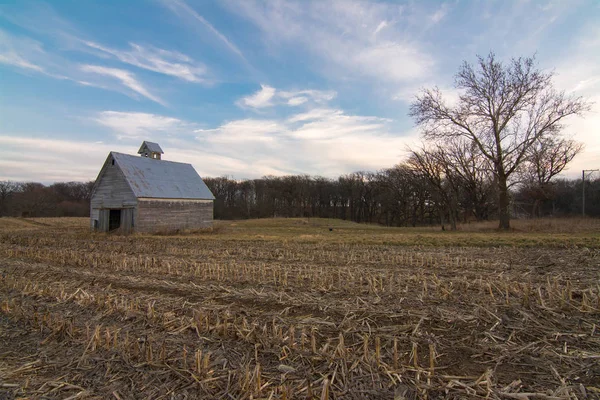 Old wooden barn in open field at sunset.  LaSalle County, Illinois, USA