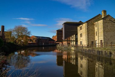 Old buildings on the side of the Leeds/ Liverpool Canal as the morning sun rises.  Wigan Pier, Wigan, England clipart