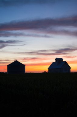 Kırsal kesimde alacakaranlıkta. Eski ahır ve arka planda güzel gökyüzü ile Silosu siluet. LaSalle County, Illinois, ABD