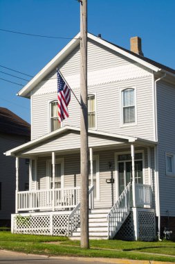 Telefon direği tipik Midwest içinde geçmiş ev ile Amerikan bayrağı. LaSalle, Illinois, ABD.