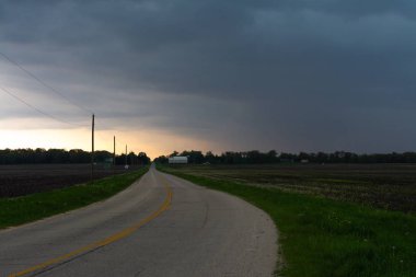 Kırsal Illinois yaklaşan fırtına bulutları ile açık ülke yolu.