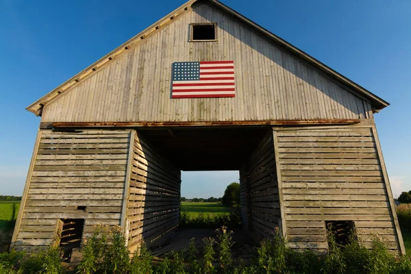 Velho celeiro de madeira com bandeira americana — Fotografia de Stock