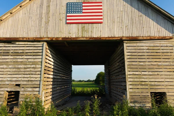 Antiguo granero de madera con bandera americana — Foto de Stock