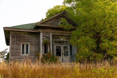 Ortabatı 'da güneş doğarken terk edilmiş eski bir okul binası. Dewitt County, Illinois, ABD
