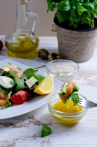 Salata üzerine odaklı salata sosa batırılmış, açık ahşap masaya yakın.