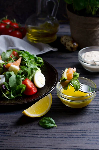 Sebze ve somonlu koyu süslemeli masaya odaklı salata, koyu arkaplanda dikey görüntü.