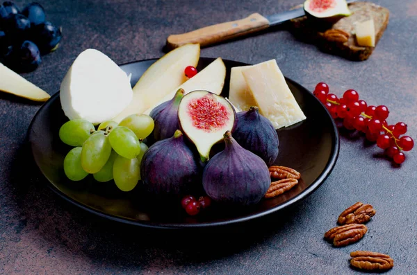 İncir, peynir, üzüm, armut ve kırmızı akımlı mozzarella, yakın plan.