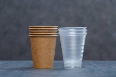 Gri arka planda bambu ahşap ve kağıttan yapılmış çevre dostu tek kullanımlık sofra takımı. Plastik tabak ve çatal bıçak takımı. Çevreye önem vermek. Geri dönüşüm sorunu. Güvenli gezegen, çevre kavramı.