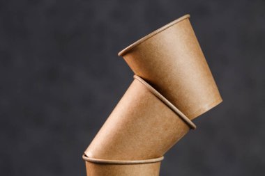 Karanlık bir arka planda tek kullanımlık kağıt bardaklar. Piknik için yemek takımı. Seninle boş kahve fincanı.