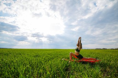 Genç atletik kadın dışarıda yoga egzersizleri yapıyor..