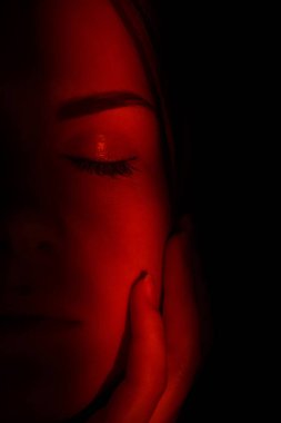 Karanlıkta ışık huzmesindeki yüksek moda modeli. Cazibeli Seksi Kız Yaratıcı Moda Portresi. Kadın yüzünde yön gösteren ışık huzmesi.