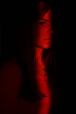 Karanlıkta ışık huzmesindeki yüksek moda modeli. Cazibeli Seksi Kız Yaratıcı Moda Portresi. Kadın yüzünde yön gösteren ışık huzmesi.