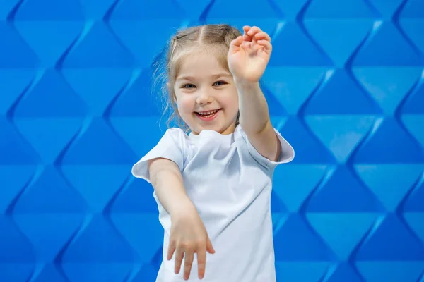 Uma Menina Com Cabelo Loiro Uma Camiseta Branca Fundo Azul — Fotografia de Stock