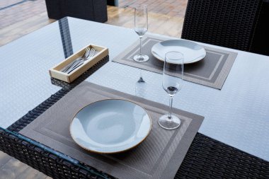 İki kişilik bir restoranda masa servisi yaptım. Yemek için mavi tabak, iki bardak. Romantik akşam konsepti