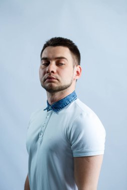 Beyaz arka planda beyaz polo giyen bir adamın portresi. Her gün için erkek imajı. Şık adam.