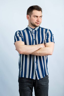Beyaz arka planda çizgili gömlekli genç bir adamın portresi. Sıradan giyinmiş şık bir adam. Her gün için erkek görüntüsü