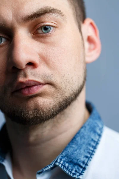 Beyaz arka planda beyaz polo giyen bir adamın yakın plan portresi. Her gün için erkek imajı. Şık adam.