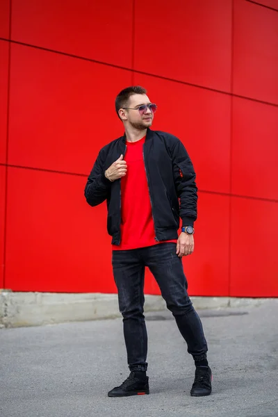 티셔츠를 선글라스를 젊은이가 야외붉은 근처에서 청바지를 거리에 현대인 스타일 — 스톡 사진