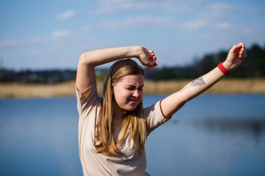 Göl kenarında dans eden bir kız, güneşli bir hava. Genç bir kadın hayattan zevk alır, dans eder ve şarkı söyler. Keyfi yerinde ve yüzünde bir gülümseme var..