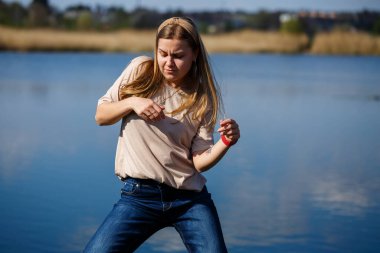 Göl kenarında dans eden bir kız, güneşli bir hava. Genç bir kadın hayattan zevk alır, dans eder ve şarkı söyler. Keyfi yerinde ve yüzünde bir gülümseme var..