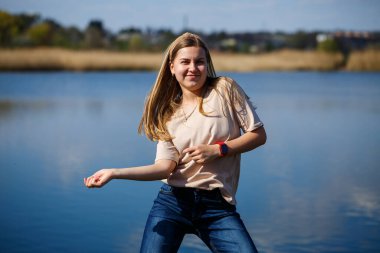 Göl kenarında dans eden bir kız, güneşli bir hava. Genç bir kadın hayattan zevk alır, dans eder ve şarkı söyler. Keyfi yerinde ve yüzünde bir gülümseme var..