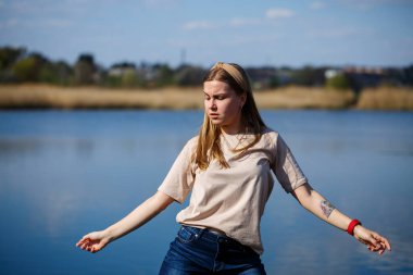 Göl kenarında dans eden bir kız, güneşli bir hava. Genç bir kadın hayattan zevk alır, dans eder ve şarkı söyler. Keyfi yerinde ve yüzünde bir gülümseme var..