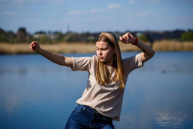 Göl kenarında dans eden bir kız, güneşli bir hava. Genç bir kadın hayattan zevk alır, dans eder ve şarkı söyler. Keyfi yerinde ve yüzünde bir gülümseme var..