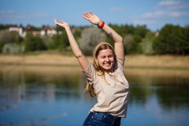 Göl kenarında dans eden bir kız, güneşli bir hava. Genç bir kadın hayattan zevk alır, dans eder ve şarkı söyler. Keyfi yerinde ve yüzünde bir gülümseme var..