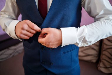 Adam düğün günü takım elbise giyer.