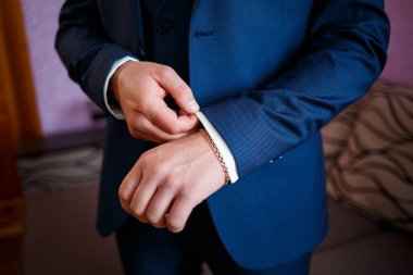 Adam düğün günü takım elbise giyer.