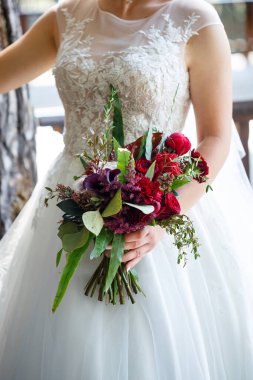Yeni evlilerin elinde güzel bir buket çiçek.