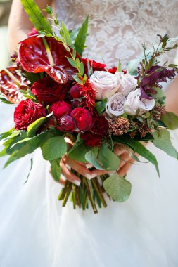 Yeni evlilerin elinde güzel bir buket çiçek.