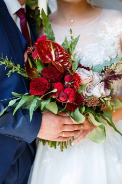 Yeni evlilerin elinde güzel bir buket çiçek.