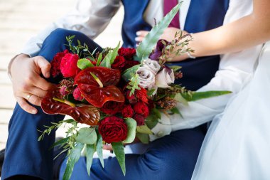 Yeni evlilerin elinde güzel bir buket çiçek.