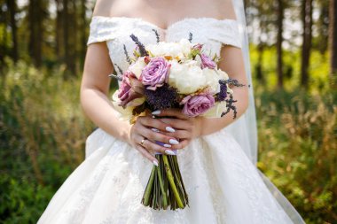 Yeni evlilerin elinde güzel bir buket çiçek.