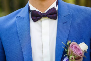 Adam düğün günü takım elbise giyer.