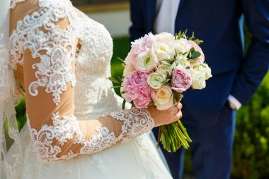 Yeni evlilerin elinde güzel bir buket çiçek.