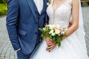 Yeni evlilerin elinde güzel bir buket çiçek.