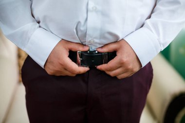 Adam düğün günü takım elbise giyer.