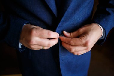 Adam düğün günü takım elbise giyer.