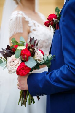 Yeni evlilerin elinde güzel bir buket çiçek.