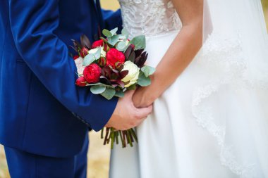 Yeni evlilerin elinde güzel bir buket çiçek.